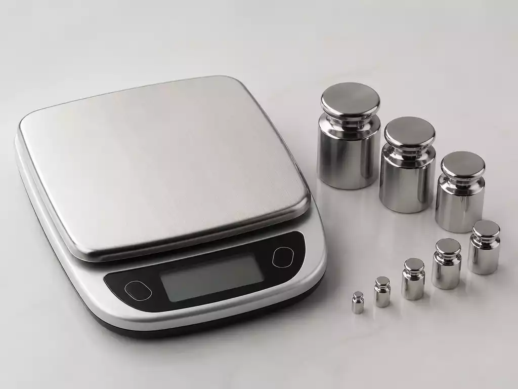 Taylor digital scale with calibration weights, on a clean, light-colored surface