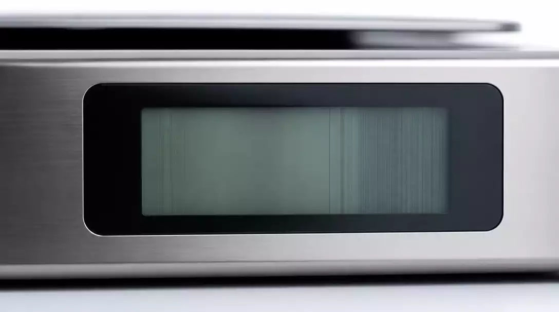 Close-up of a malfunctioning digital scale display showing garbled numbers