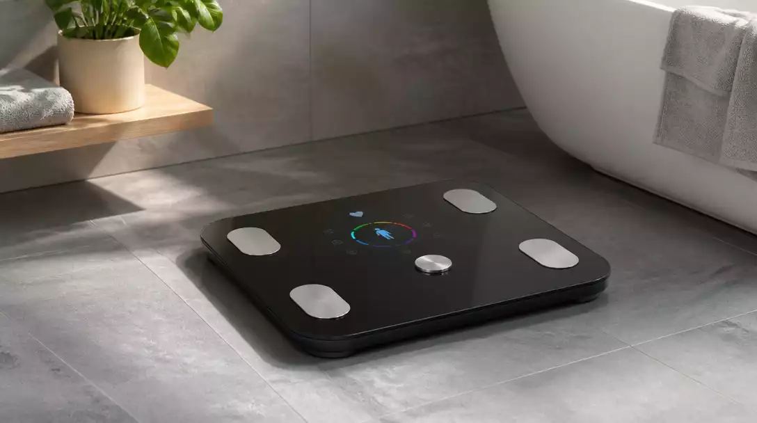 Smart scale displaying various health metrics on a digital screen