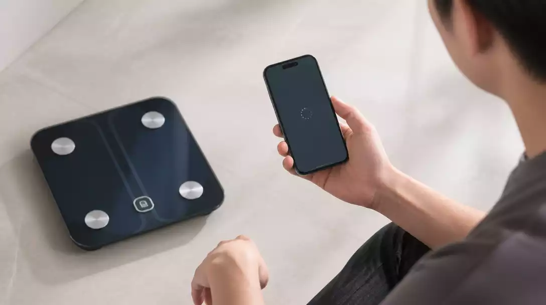 Person troubleshooting a Eufy smart scale with a smartphone, showing connection issues